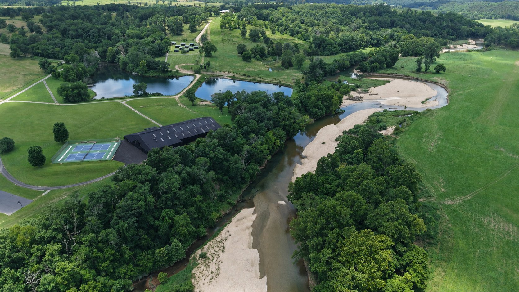 Aerial view of Big Sugar Creek winding through the Ozark Adventure Club property
