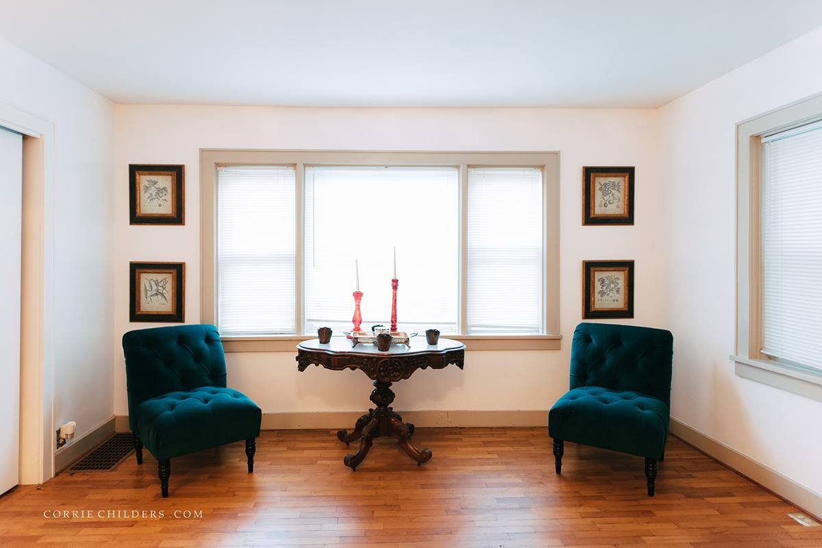 Sitting area with teal accent chairs and antique side table