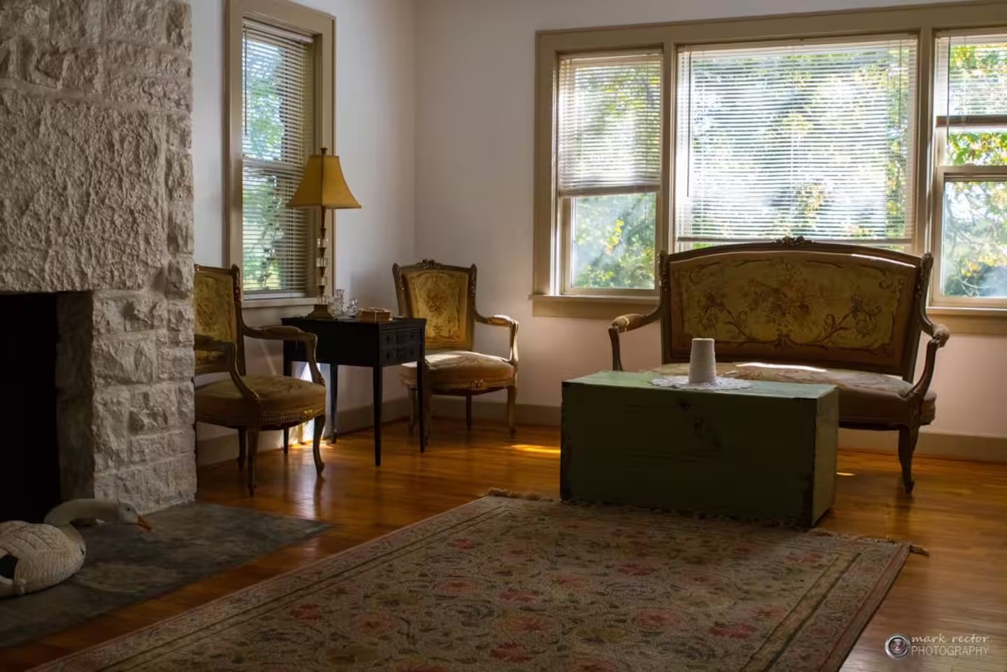 Sitting room with natural stone fireplace and antique furnishings